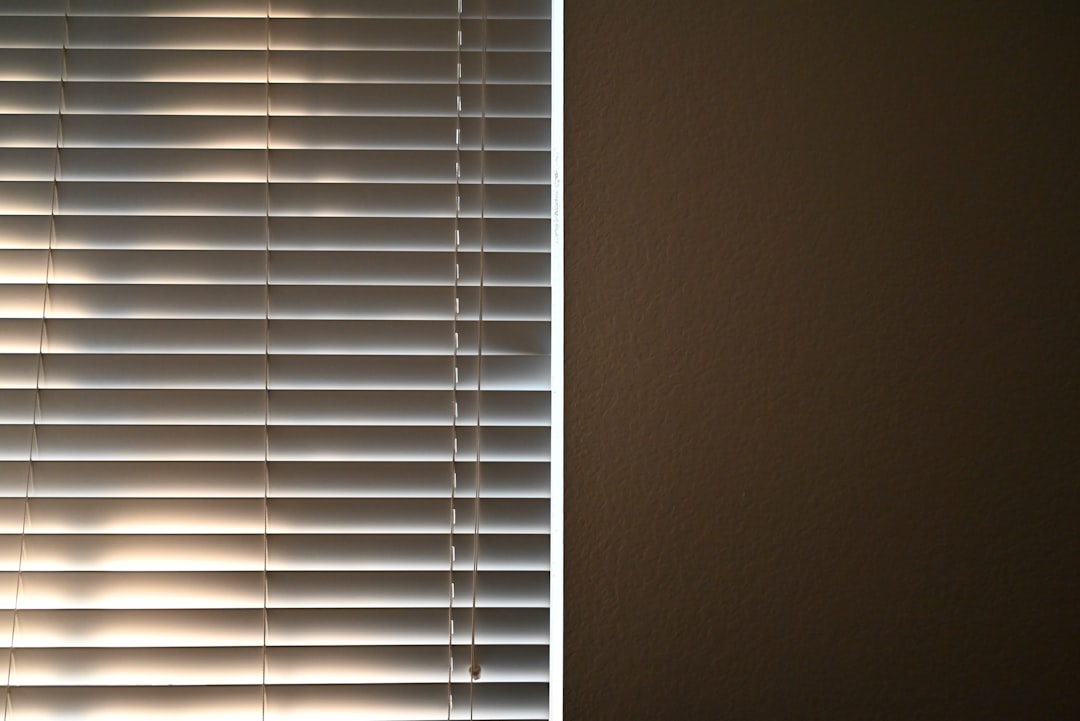 a-window-covered-in-blinds-with-a-cloud-in-the-background-mmfr2evsw4o